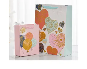 Detail of glittery heart and balloon patterns on festive paper gift bags