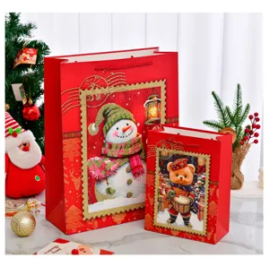 Detailansicht roter Weihnachtsgeschenktüten mit festlichen Schneemann- und Bärenmotiven