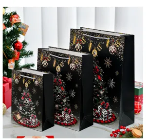 Detailansicht schwarzer Weihnachts-Geschenktüten in drei Größen mit Goldfolien-Baum.