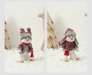 Détail de mini bonhommes de neige skieurs de Noël avec bonnets rouges et skis en bois.