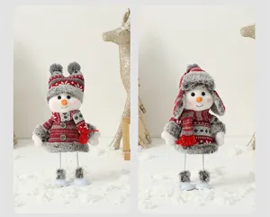 Vue détaillée de deux poupées en peluche bonhomme de neige de Noël en tenues festives.
