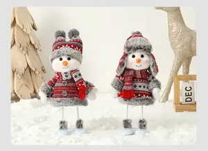 Détail de deux poupées bonhommes de neige créatives avec bonnets et écharpes en peluche