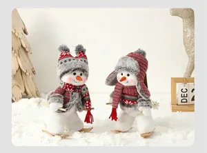 Détail de deux bonhommes de neige en peluche avec bonnets en tricot et skis pour Noël
