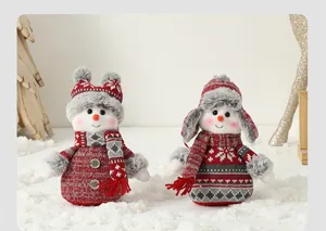 Gros plan de deux peluches bonshommes de neige de Noël en tenues tricotées festives