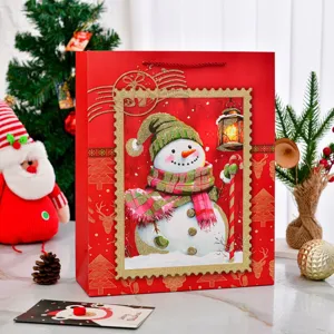 Große rote Weihnachts-Geschenktüte aus Papier mit Schneemann-Motiv und Dekorationen