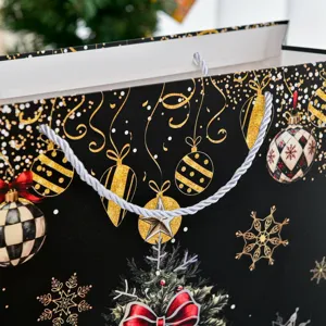 Schwarze Weihnachts-Geschenktüte mit Goldfolien-Ornamenten und Silberkordel-Griffen.