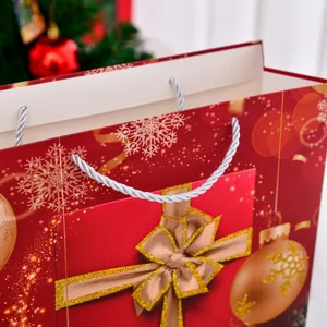 Festive large red Christmas gift bag with snowflake patterns and silver rope handles.