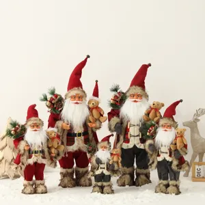 Group of Christmas Santa Claus dolls holding teddy bears in festive snow scene