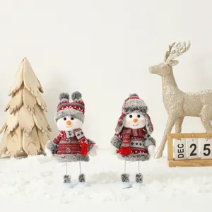 Paire de jolies peluches bonhomme de neige de Noël avec bonnets et écharpes sur neige