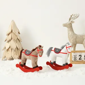 Deux jolis chevaux à bascule de Noël en peluche sur de la neige avec décor festif