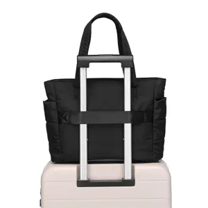 Black quilted travel bag with back sleeve for suitcase handles for easy transport.