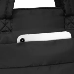 Close-up detail of the exterior slide pocket on a black quilted nylon travel tote bag