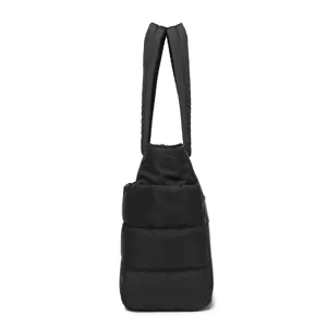 Side view showing the quilted texture of a black padded travel puffer tote bag