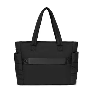 Black quilted travel tote bag featuring a practical rear luggage sleeve for travel