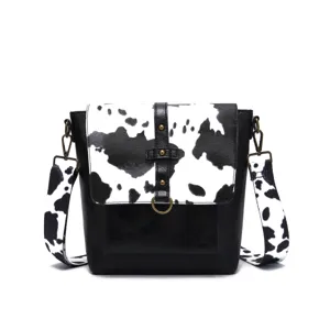 Front detail view of Western vintage cow print bag with black flap and wide strap