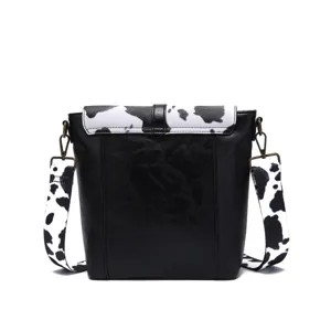 Rear perspective showing cow print pattern flap and strap on western crossbody bag