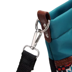Close-up of durable metal hook and leather strap attachment on a retro nylon bag.