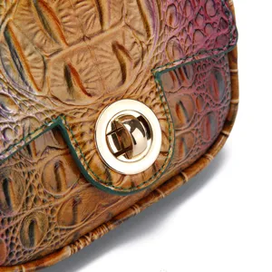 Primer plano del cierre giratorio dorado en bolso vintage con grabado cocodrilo