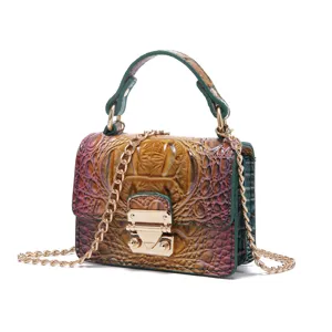 Primer plano de bolso bandolera vintage con patrón de cocodrilo y detalles dorados