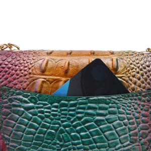 Primer plano de bolso multicolor con grabado de cocodrilo y detalle de bolsillo