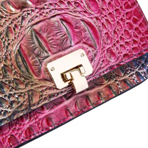Detalle del bolso con relieve de cocodrilo magenta y cierre metálico dorado de lujo