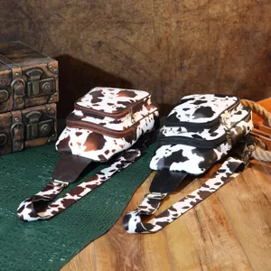 Vintage bohemian cow print sling bags in black and brown with multi-zipper compartments