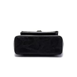 Close-up shot of the textured black faux leather base on a vintage western crossbody bag