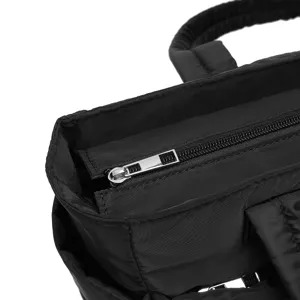 Close-up of durable silver zipper on high-quality black quilted travel bag fabric