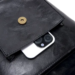 Close-up detail of black vintage leather bag pocket showing texture and magnetic snap
