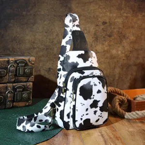 Retro western-style cow print sling bag for women shown in a vintage scenic setting