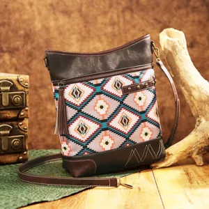 Detail view of retro Aztec print crossbody bag with tassel and leather trim