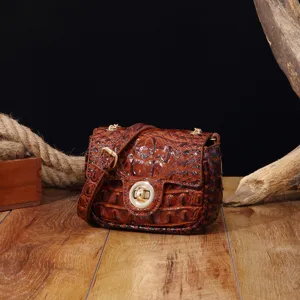 Detalle de textura de bolso bandolera marrón con relieve de cocodrilo sobre madera