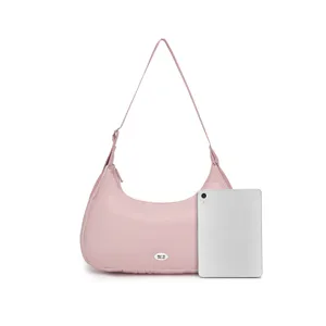 Bolso hobo acolchado rosa claro junto a una tableta para comparar el tamaño.