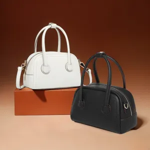 Vista detallada de los mini bolsos Boston de piel blanca y negra con textura elegante.