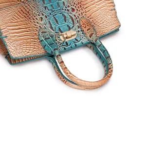 Dettaglio della trama in pelle goffrata coccodrillo e chiusura dorata su borsa vintage