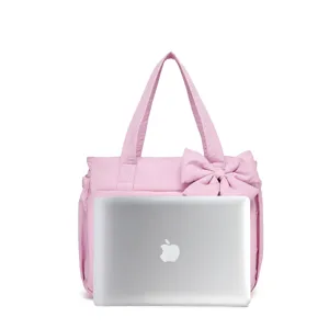 Grande borsa tote trapuntata rosa con fiocco, confronto delle dimensioni con un laptop