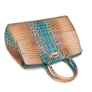 Dettaglio di una borsa vintage con motivo coccodrillo e sfumatura verde acqua.