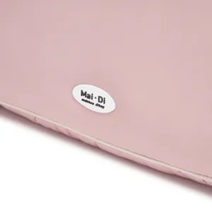 Primer plano de un bolso de nube rosa acolchado con detalle de etiqueta de marca blanca.