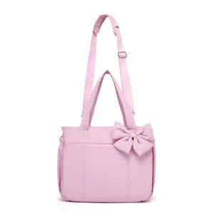 Borsa a tracolla in nylon rosa con dettaglio fiocco e tracolla regolabile.