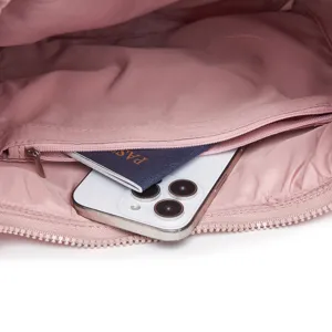 Detalle del bolsillo interior con cremallera de un bolso acolchado rosa muy suave