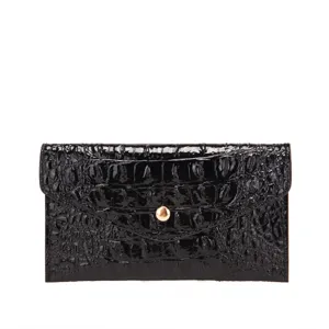 Primer plano de un bolso de mano negro brillante con diseño de cocodrilo y cierre dorado.