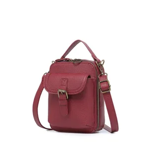 Bolso bandolera de cuero rojo con bolsillo delantero con hebilla y asa superior robusta.