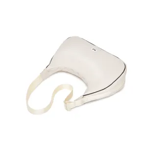 Detalle de un bolso de media luna acolchado blanco crema con relleno suave y correa