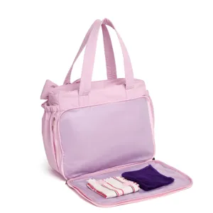 Dettaglio della borsa da viaggio trapuntata rosa con scomparto anteriore apribile piatto.