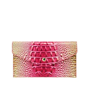 Primer plano de textura de piel de cocodrilo rosa vibrante en cartera sobre mujer