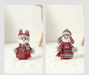 Gros plan de deux poupées bonhommes de neige de Noël avec corps en tricot rouge et bonnets