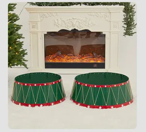 Green and red metal Christmas tree collar fence with star patterns in a cozy fireplace setting.