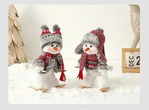 Paire de bonhommes de neige skieurs avec bonnets rouges dans un décor d'hiver