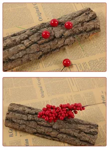 Close-up of artificial red berries on natural tree bark for rustic Christmas decor.