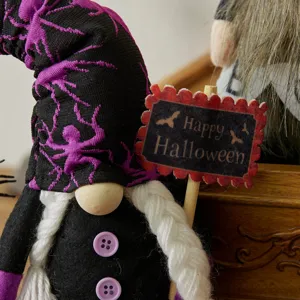 Spooky Halloween gnome decoration with purple spiderweb hat and Happy Halloween sign